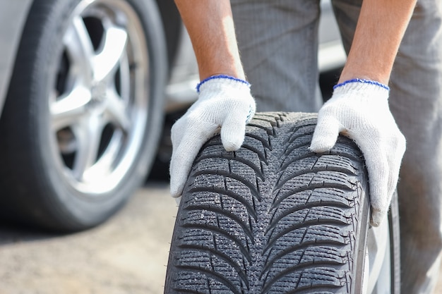 A dopo un guasto, una persona cambia una ruota di un'auto