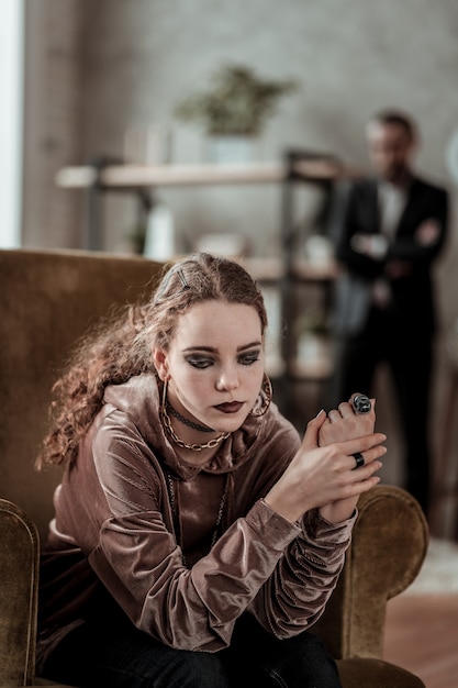 After family problems. Curly teenage girl with smoky eyes feeling depressed after family problems