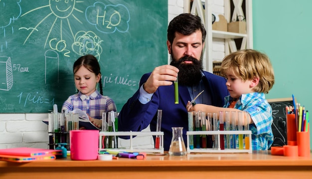 After school clubs are great way to develop kids in different areas Clubs for preschoolers Chemistry experiment School clubs interactive education Teacher and pupils test tubes in classroom