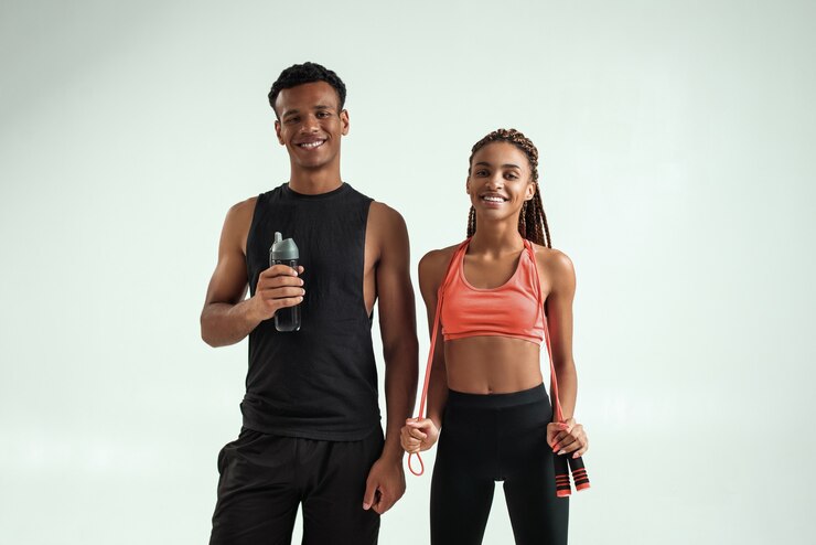 Photo after training young and positive sporty african couple in sportswear looking at camera while