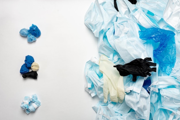 Afval van gebruikte persoonlijke beschermingsmiddelen PBM, handschoenen, wegwerpmaskers, overschoenen van medisch personeel. Vuilnisverontreiniging na de COVID-19-pandemie