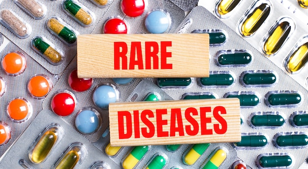 Against the background of multi-colored plates, wooden blocks with the text RARE DISEASES. Medical concept.
