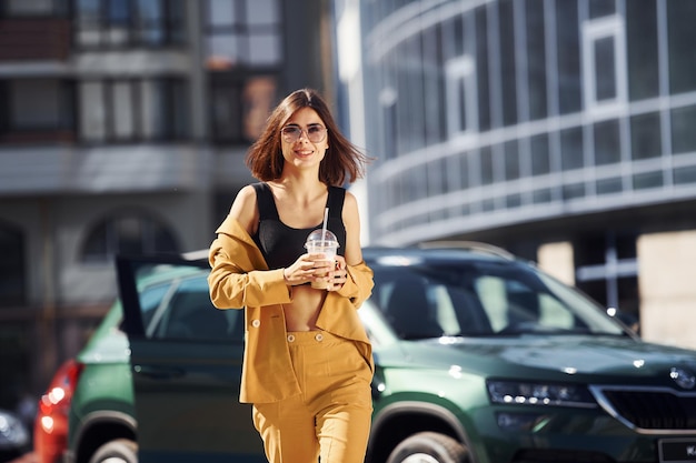 彼女の車で日中にバーガンディ色のコートで若いファッショナブルな女性を構築するビジネスに対して