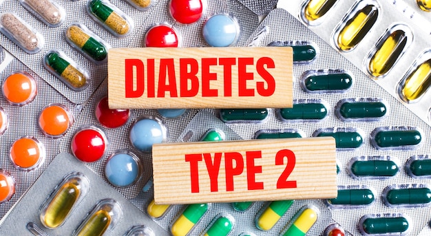 사진 다양한 색상의 판을 배경으로 diabetes type 2라는 텍스트가 있는 나무 블록. 의료 개념.