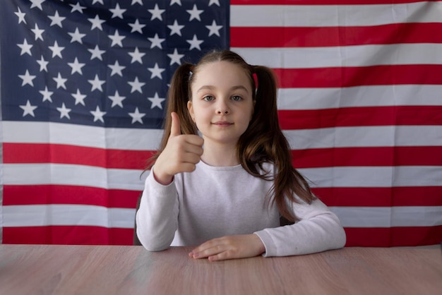 https://img.freepik.com/premium-photo/against-the-background-of-the-american-flag-a-schoolgirl-sits-at-home-with-the-thumb-raises-up-patriotism-and-flag-day-webcam-view_275234-2791.jpg