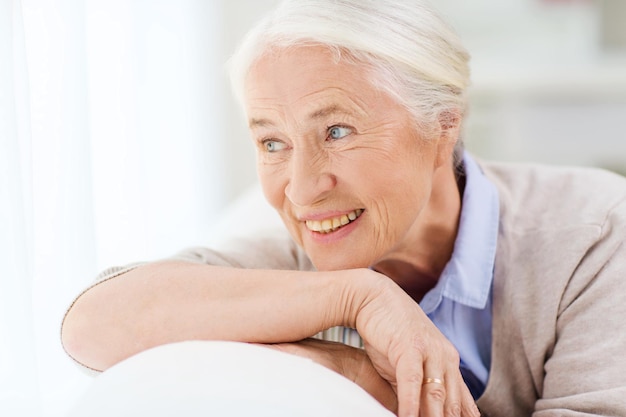 age and people concept - happy smiling senior woman face at home