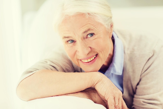 age and people concept - happy smiling senior woman face at home