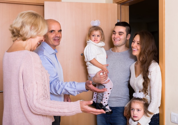 Aged couple meeting family at doorstep