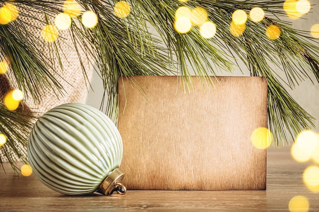 Aged kraft paper texture copy space with Christmas bauble on bokeh lights background Cozy home decor