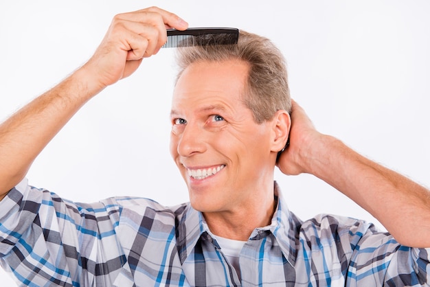 Aged man combing his hair