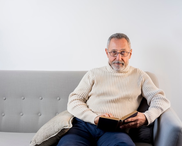 Foto uomo invecchiato leggendo con gli occhiali