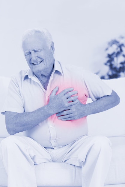 aged man suffering with heart pain on a sofa