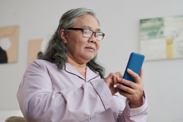 Photo aged woman answering text messages