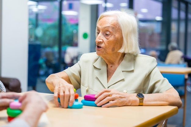 Aged woman in a nursing home sharing skills games