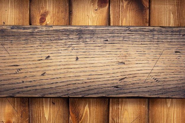 Aged wooden nameplate at wood board background