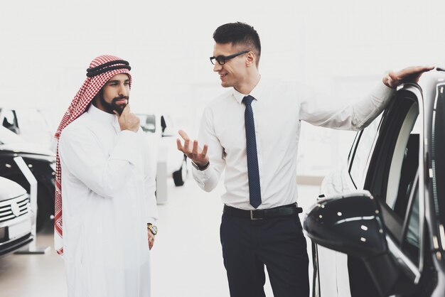 Agente che dimostra il pensiero del cliente arabo dell'automobile.