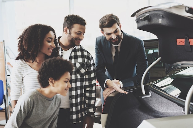 Foto l'agente mostra la famiglia del veicolo che ispeziona la nuova automobile