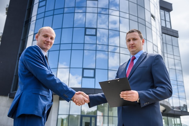 Agent with buyer posing on construction site