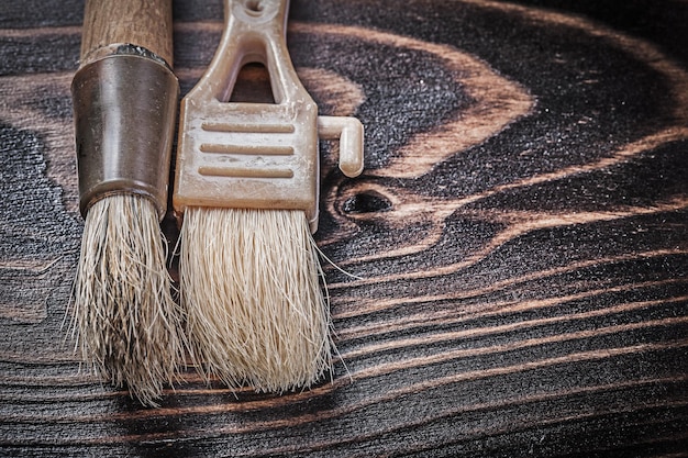 Ageold paintbrushes on wooden board horizontal version construction concept