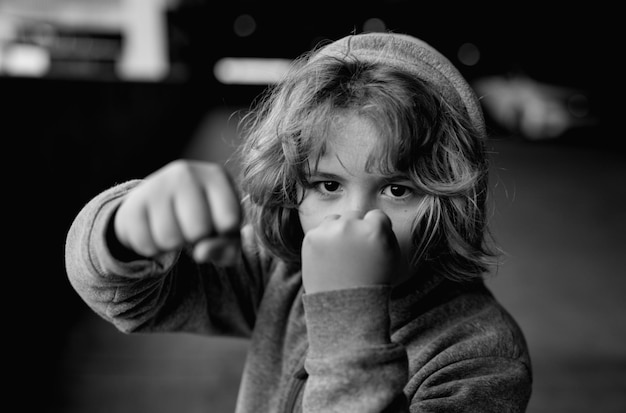 Photo aggressive anger child little kid boy anger on street angry little boy showing fist portrait of