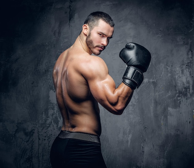 Aggressive shirtless boxer on grey background. Studio shot