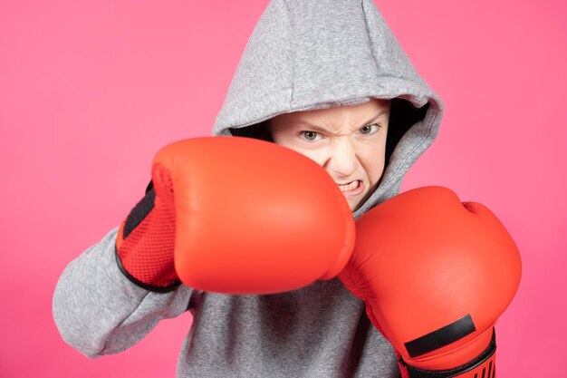 Aggressive teenager boy hitting with boxing gloves