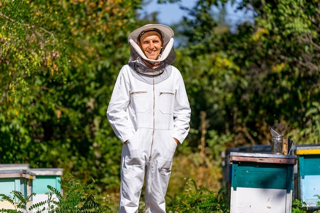Foto agrarische imker in beschermende doek poseren voor camera man onderzoekt netelroos in de zomer