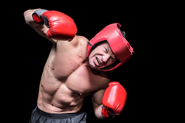Agressieve bokser die tegen zwarte achtergrond puching