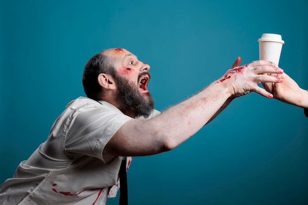 Agressieve zombie die een koffiekopje wil drinken