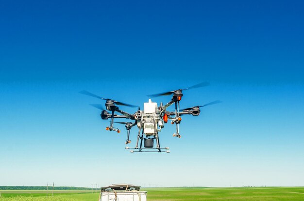 Agricultural drone in flight on a background of blue sky Field spraying new technologies