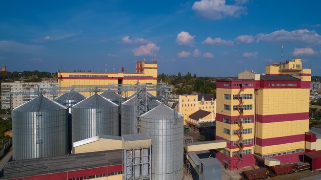 Agricultural Silo Storage and drying of grains wheat corn soy against the blue sky with clouds