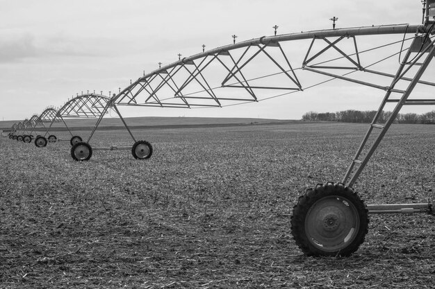 Agricultural sprinkler on field against sky