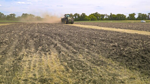 Agricultural tractor moving on farming field Farming machinery Rural field