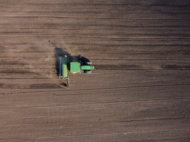Сельскохозяйственный трактор пашет поле почвы под посев
