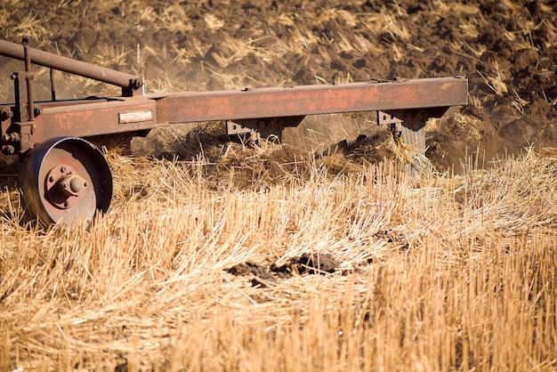 Agriculture blue tractor plowing in autumn on the field