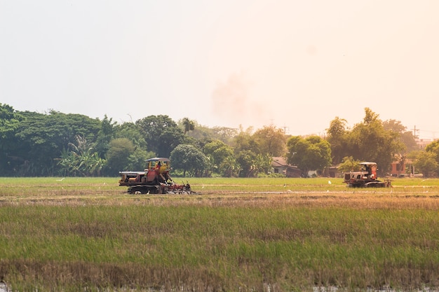 Agriculture farmland,tractor with plough ploughing a soil field