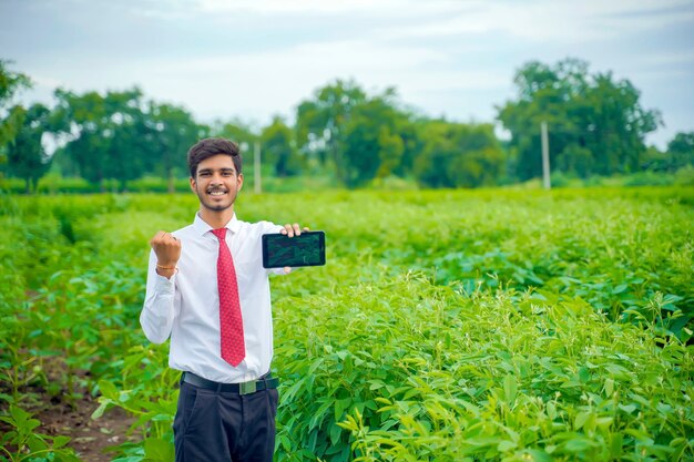 Agronomist at cotton field with smartphone