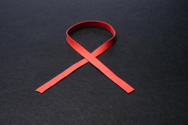 Aids awareness red ribbon isolated on black background