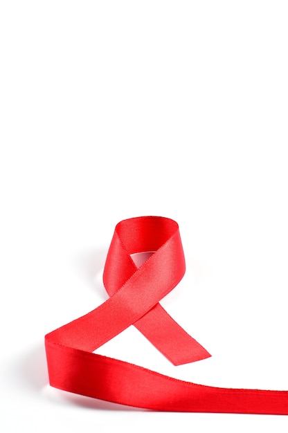 白い背景の上のエイズ認識赤いリボン。