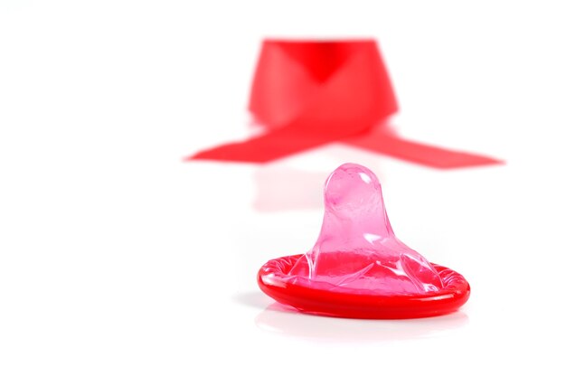 Photo aids ribbon and condom on white background.