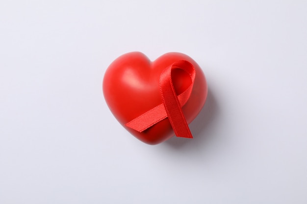 AIDS-voorlichtings rood lint en hart op witte muur, ruimte voor tekst