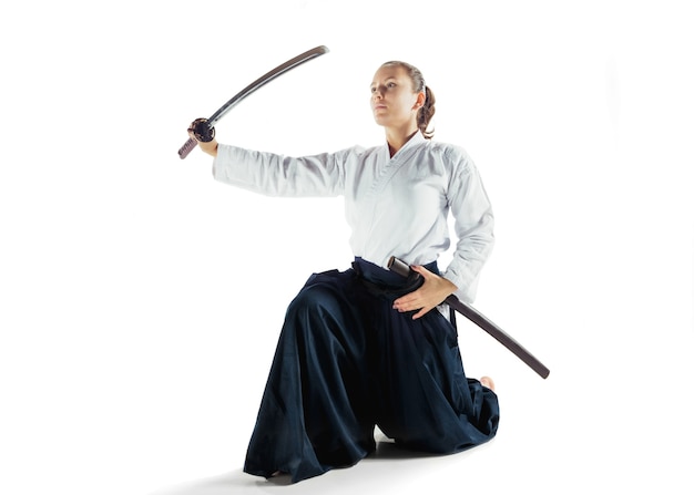 Aikido master practices defense posture. Healthy lifestyle and sports concept. Woman in white kimono on white background. Karate woman with concentrated face in uniform.