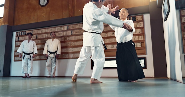 Aikido sensei en Japanse studenten met discipline fitness en actie in de klas voor verdediging of techniek Martial arts mensen of vechten met training uniform of vertrouwen voor cultuur en vaardigheid