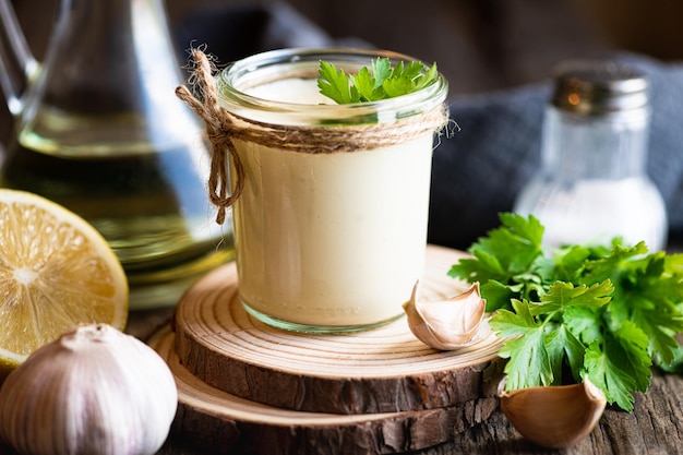 Aioli sauce in a glass jar on a wooden background selective focus