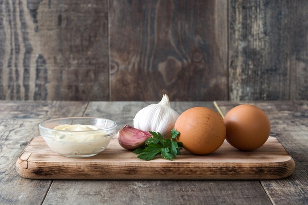 Aioli sauce and ingredients on wooden table