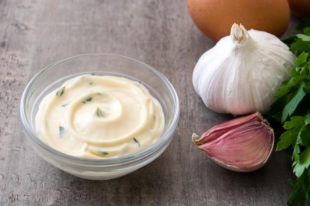 Aioli saus en ingrediënten op houten tafel