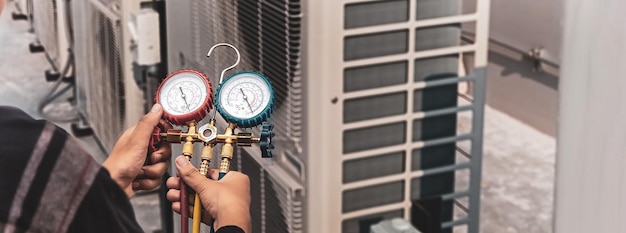 Air conditioner technician repairing central air conditioning system with outdoor tools.