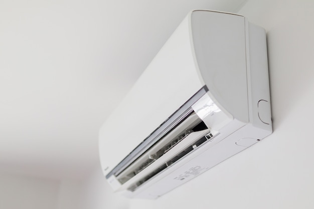 Air conditioner on white wall room interior background