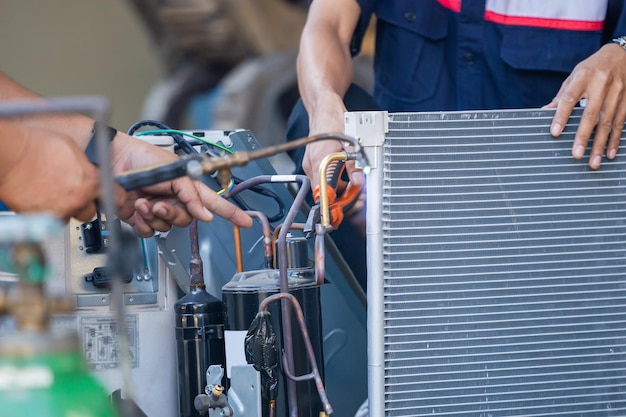 Air conditioning repair team use fuel gases and oxygen to weld\
or cut metals oxyfuel welding and oxyfuel cutting processes\
repairman on the floor fixing air conditioning system