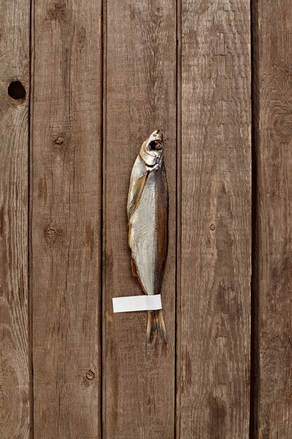 Air-dried sabrefish with label on tail on wooden background